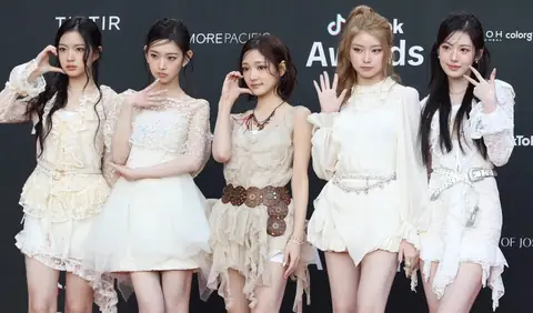 The five members of KiiiKiii wearing white, flowy mini dresses on the red carpet of the 2025 TikTok Korea Awards